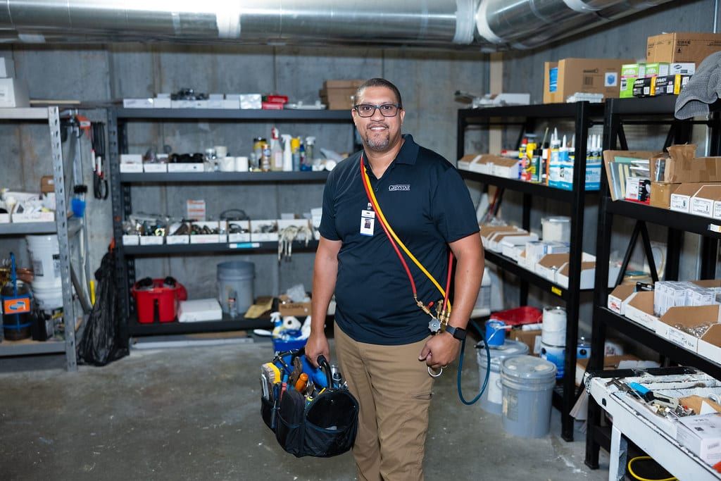 A technician with a tool bag in a stocked supply room